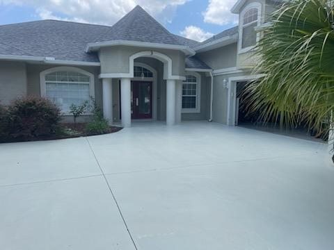 Freshly painted gray Palm Coast home with a clean concrete driveway