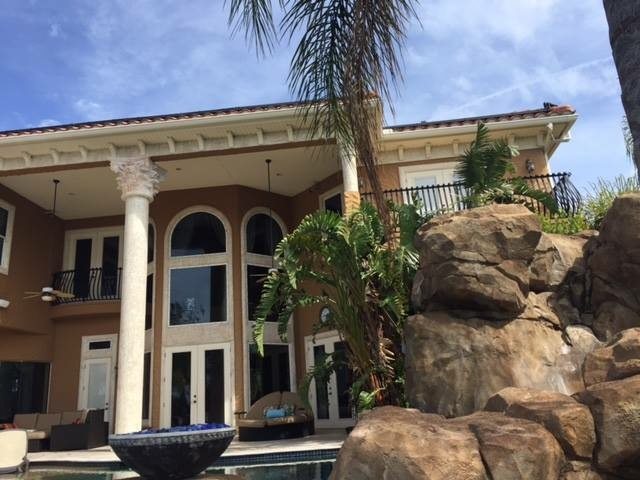 Large Mediterranean-style pool home with a painted exterior