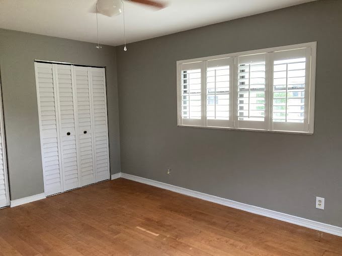 Fresh gray bedroom walls with clean white trim and shutters